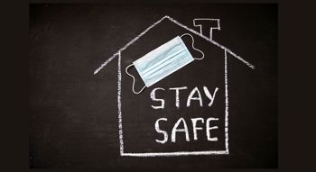 Chalk house on a blackboard with Stay Safe written on it