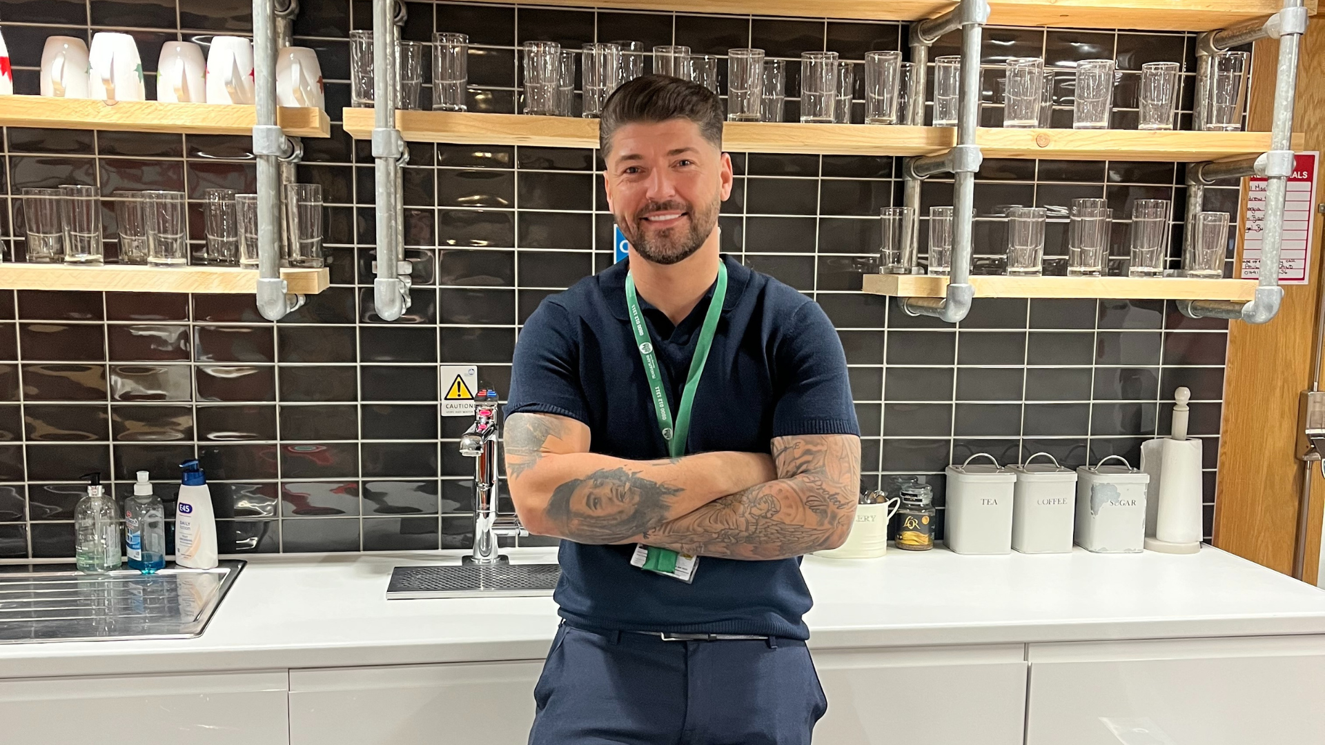 Jamie Cunningham, our Gas Manager, stands in the Trust's office kitchen. He crosses his arms and smiles confidently at the camera.